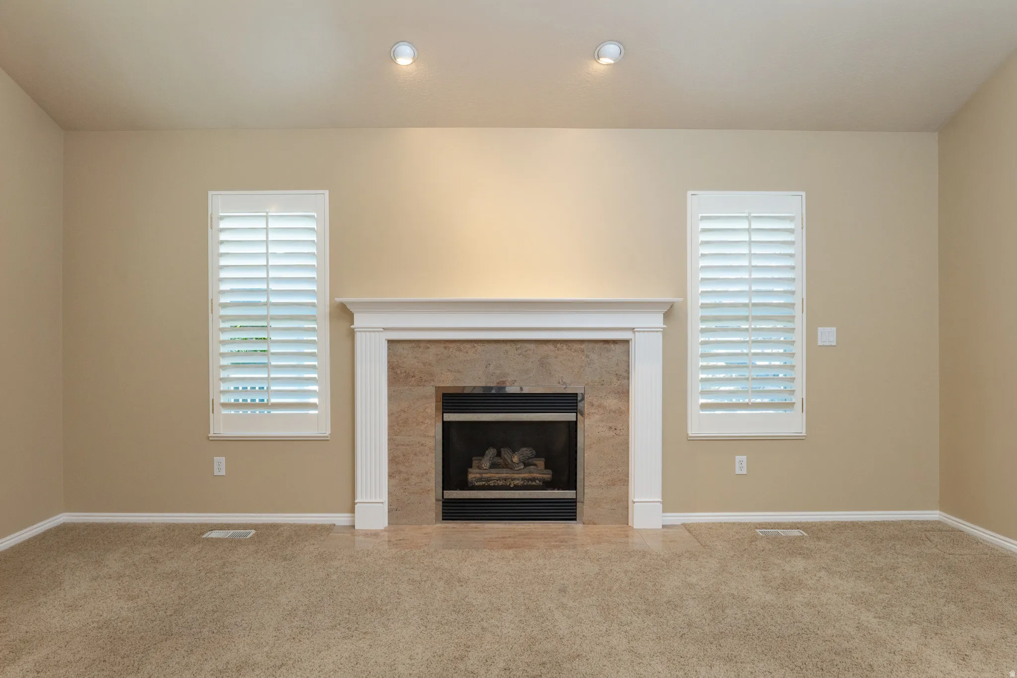 Living area featuring a central fireplace with a stone surround and a white mantel