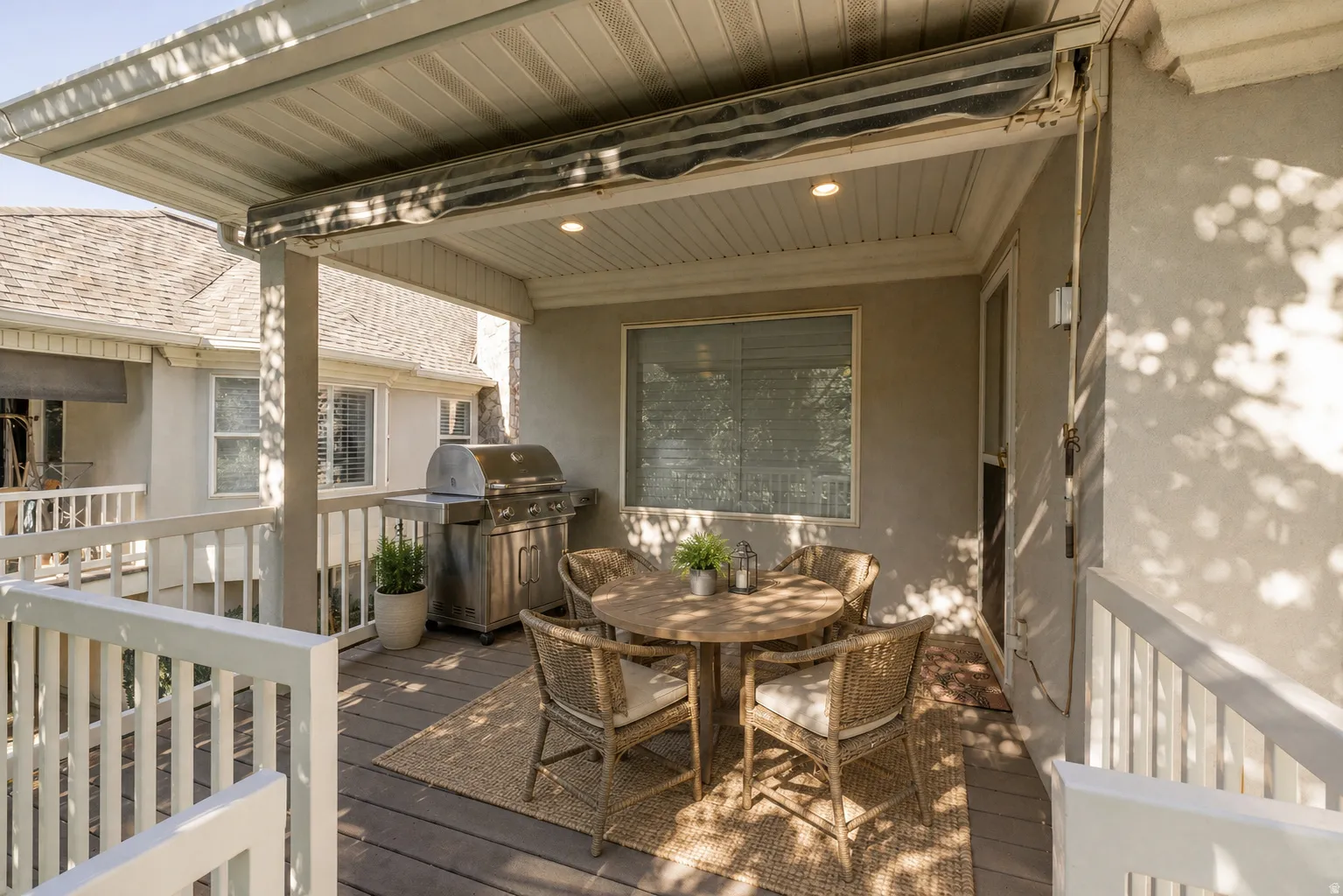Virtually Staged - Covered outdoor deck with white railing, wood-finish flooring, and recessed lighting
