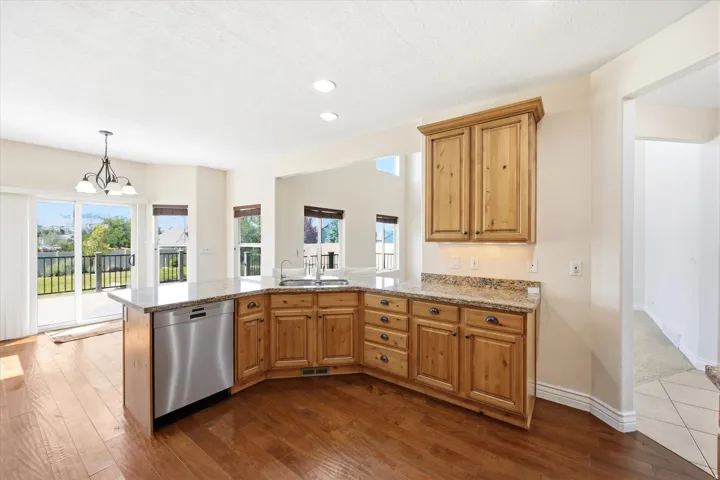 Kitchen featuring wood-finish cabinetry, light-toned countertops, and an integrated stainless steel dishwasher