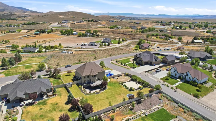 Expansive property featuring a large landscaped lawn, an elevated deck, mature trees, and a privacy fence
