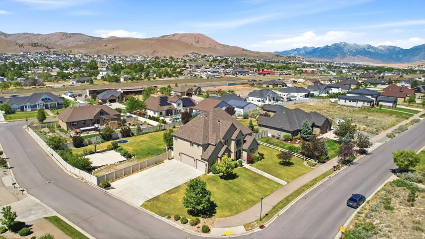 Corner lot residence featuring a two-car garage, concrete driveway, and mature landscaping