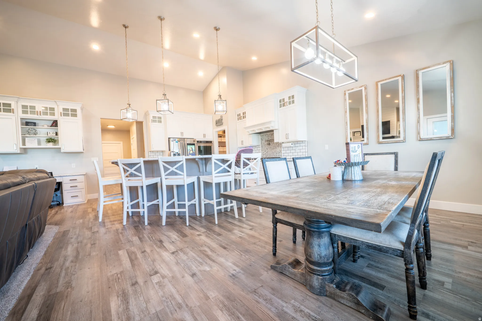 Open-concept living area featuring wood-finish flooring, vaulted ceilings, and recessed lighting