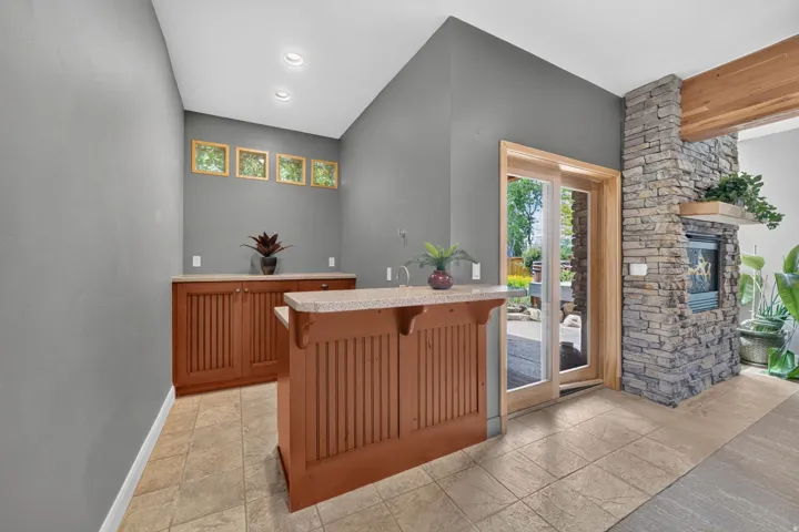 Built-in wet bar featuring natural wood cabinetry and a light-colored countertop