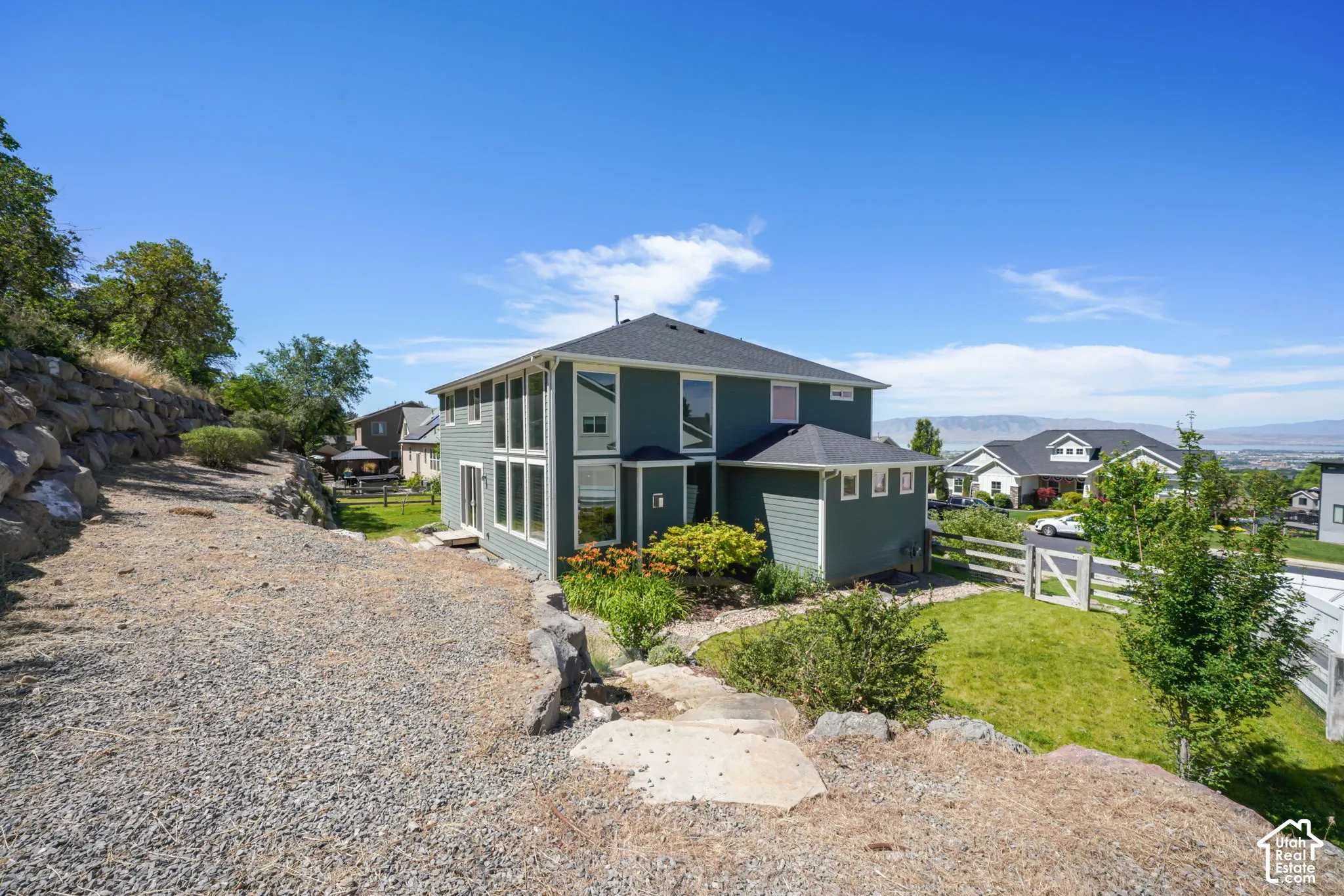 Split-level residence featuring a dark blue siding exterior with white trim
