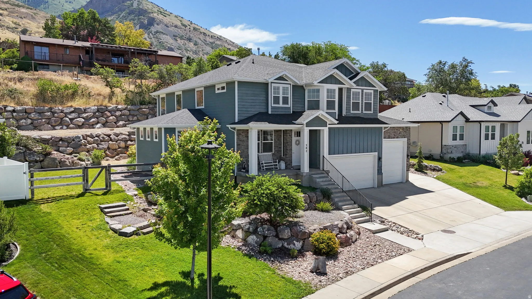 Two-story residence featuring a gray shingle roof and blue horizontal siding