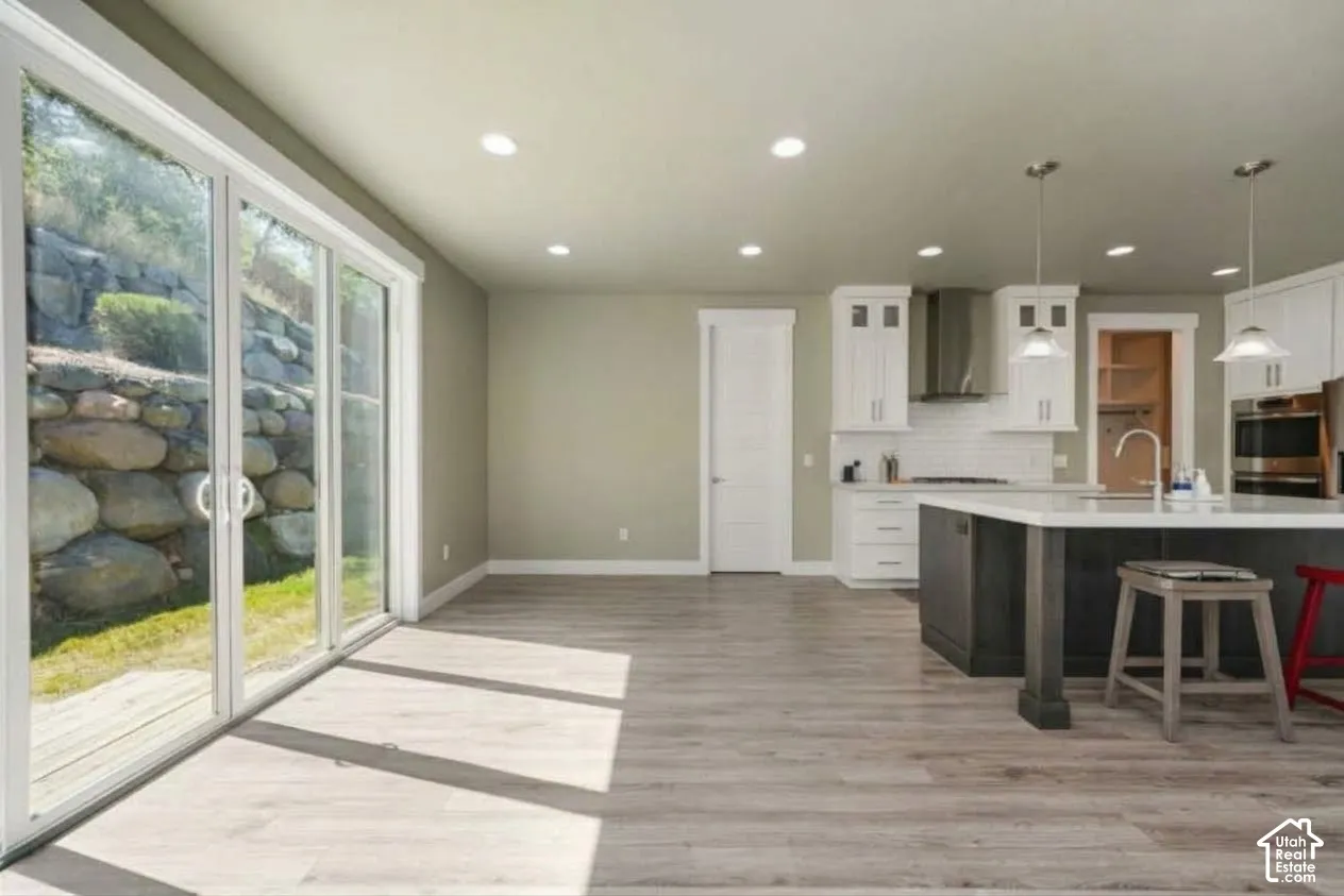 Open-concept living space with wood-finish flooring, recessed lighting, and sliding glass doors