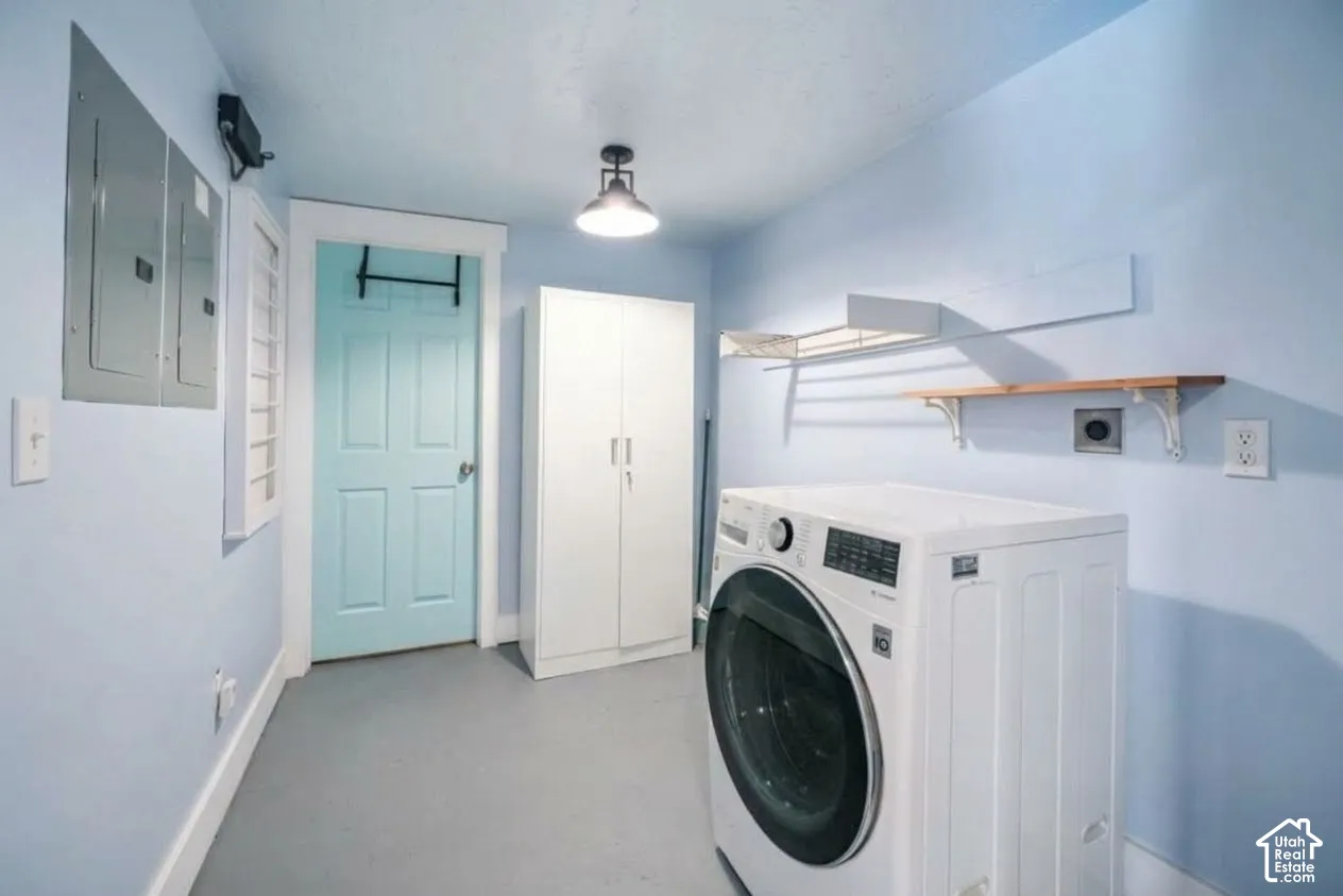 Dedicated laundry space featuring a light blue door, white built-in storage cabinet, and wall-mounted shelving
