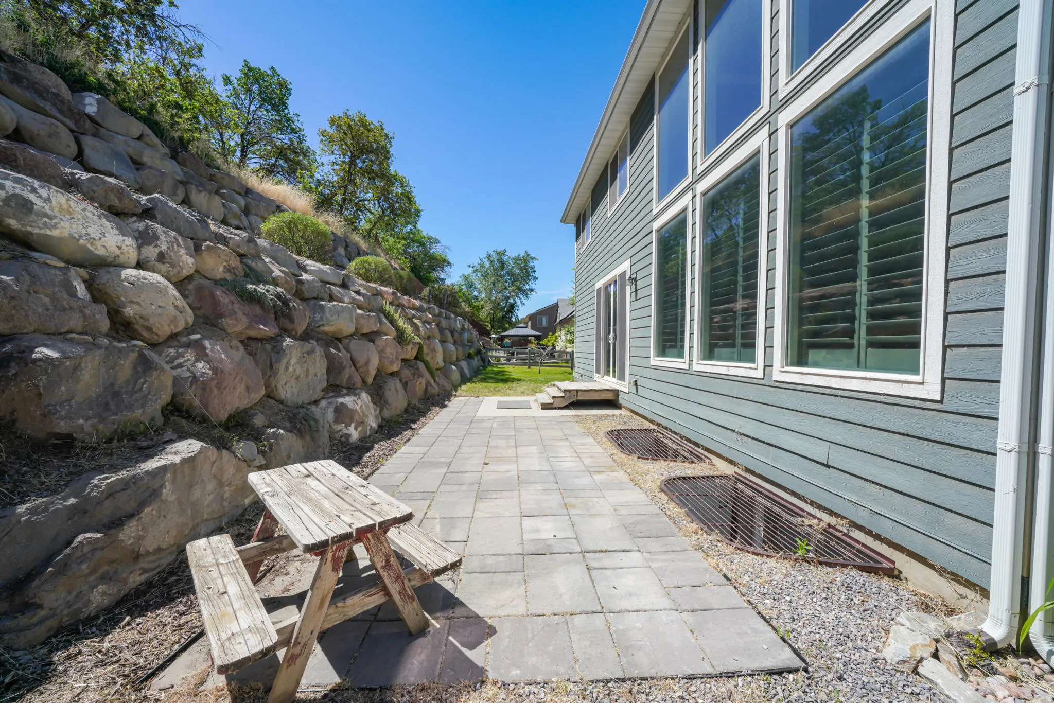 Exterior stone retaining wall and a paver patio space