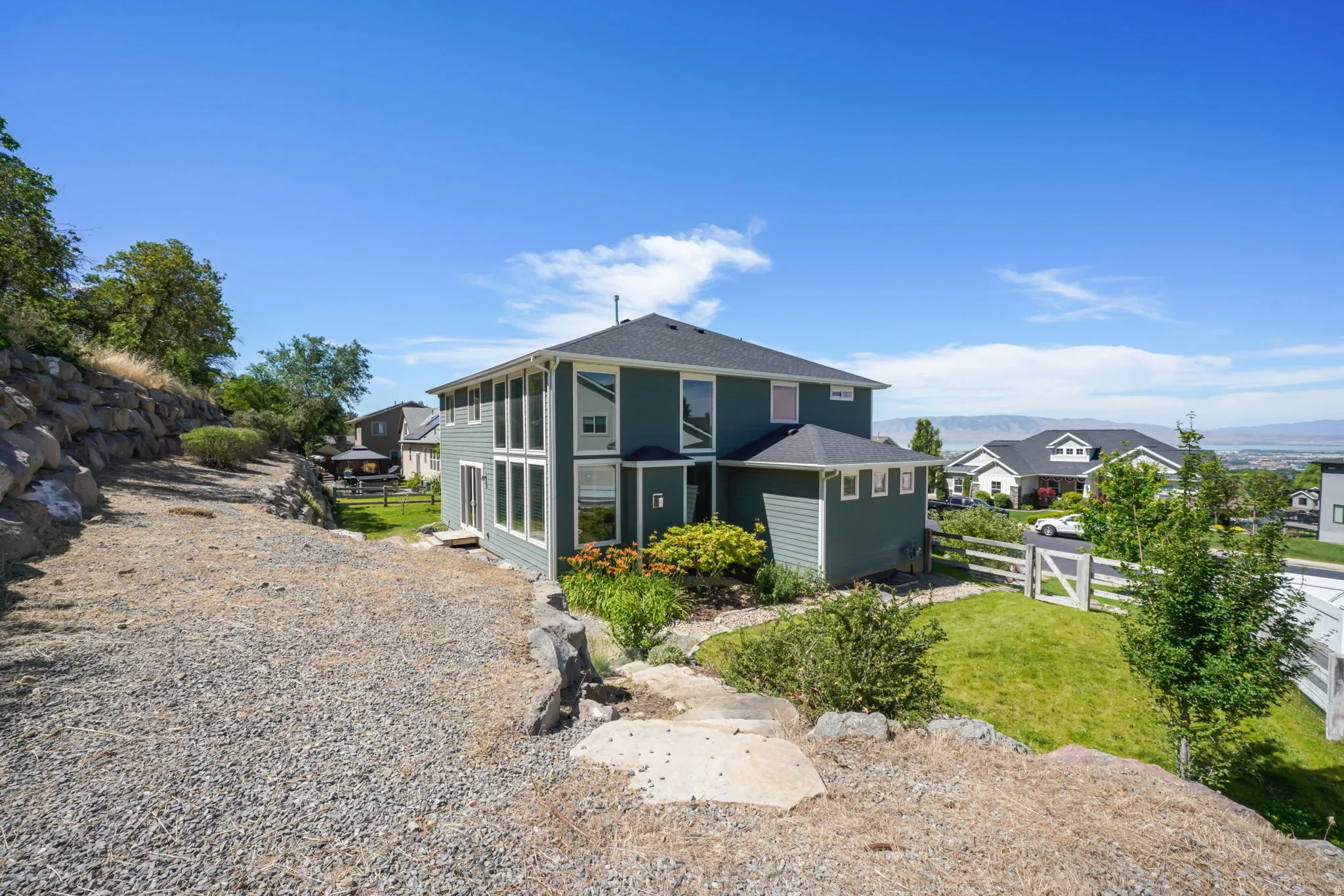 Split-level residence featuring a dark blue siding exterior with white trim