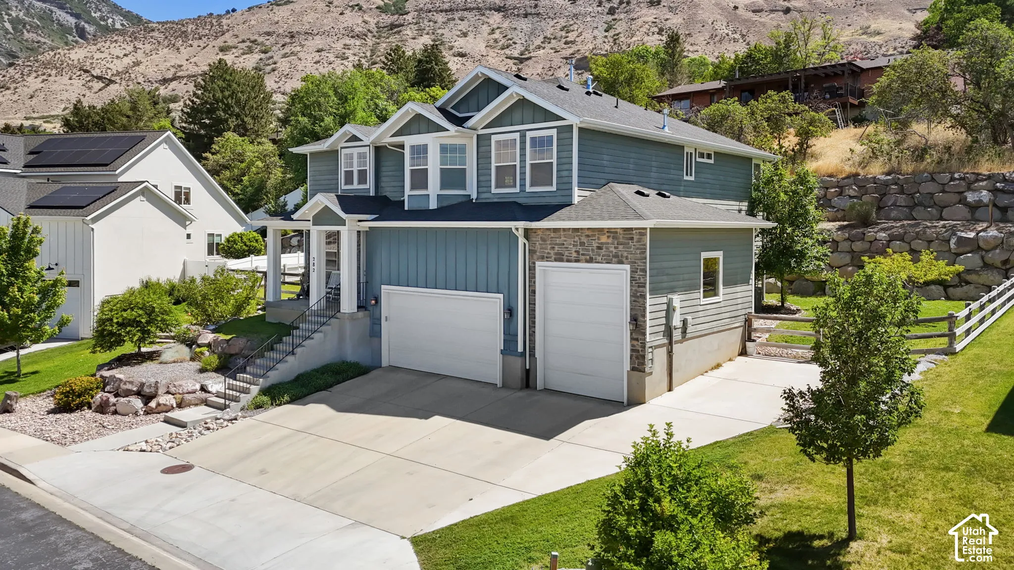 Contemporary residence featuring a two-car garage, an additional single-car garage, and a concrete driveway