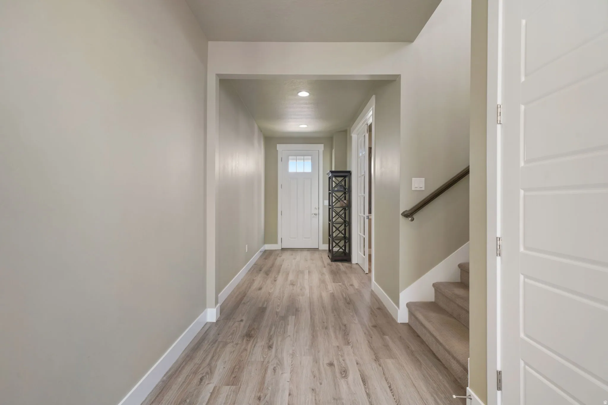 Entryway featuring wood-finish flooring, light neutral wall paint, recessed lighting, white baseboards, and a white paneled entry door with frosted glass accents