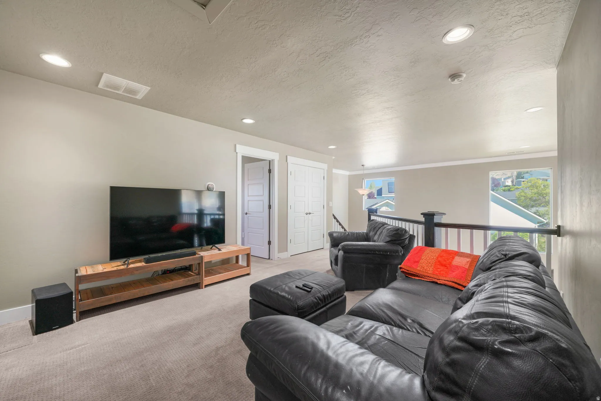 Carpeted loft space featuring recessed lighting and a white banister