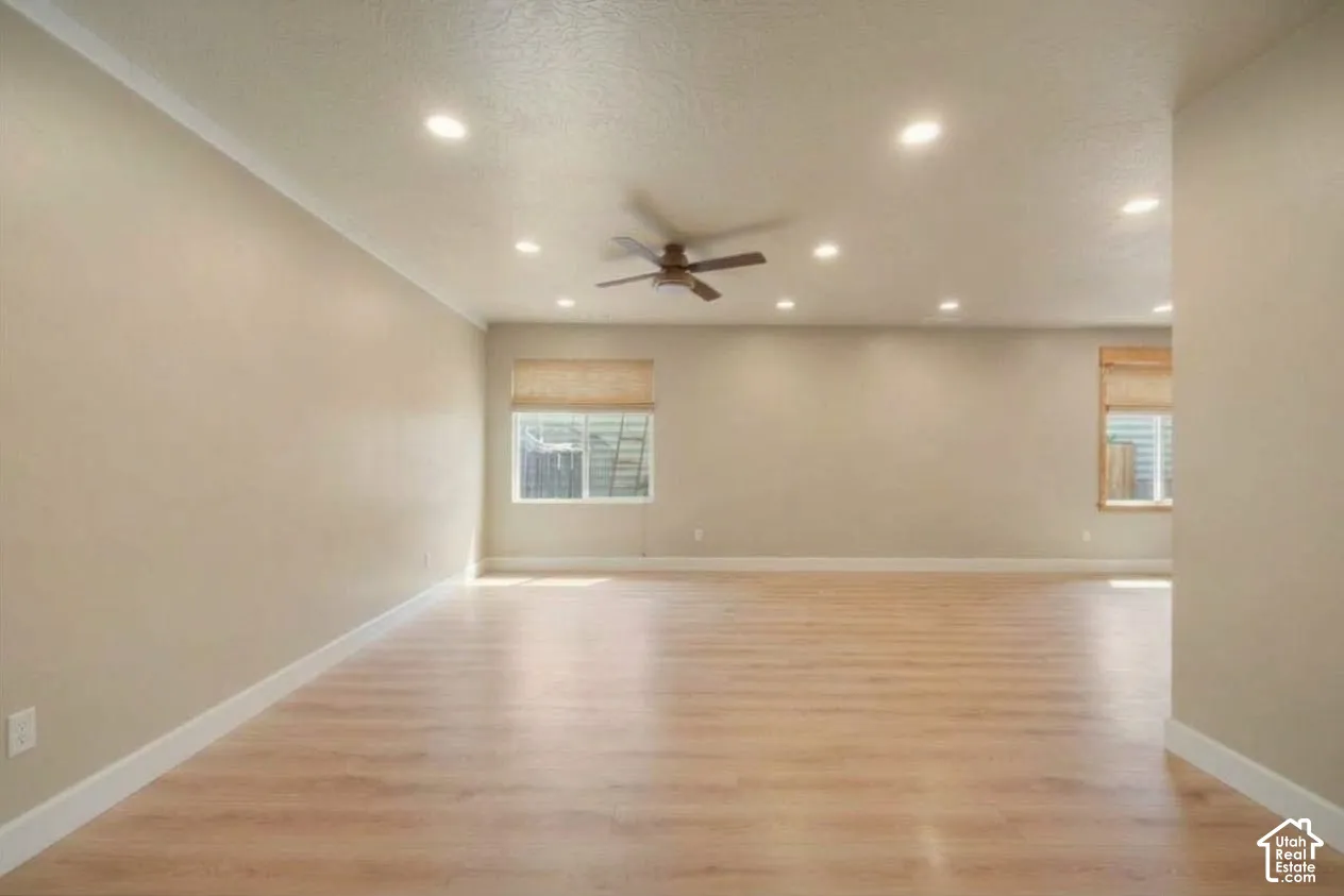 Recessed lighting, wood-finish flooring, ceiling fan, and window treatments