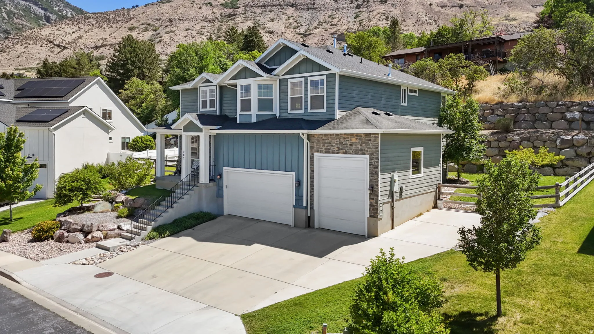 Contemporary residence featuring a two-car garage, an additional single-car garage, and a concrete driveway