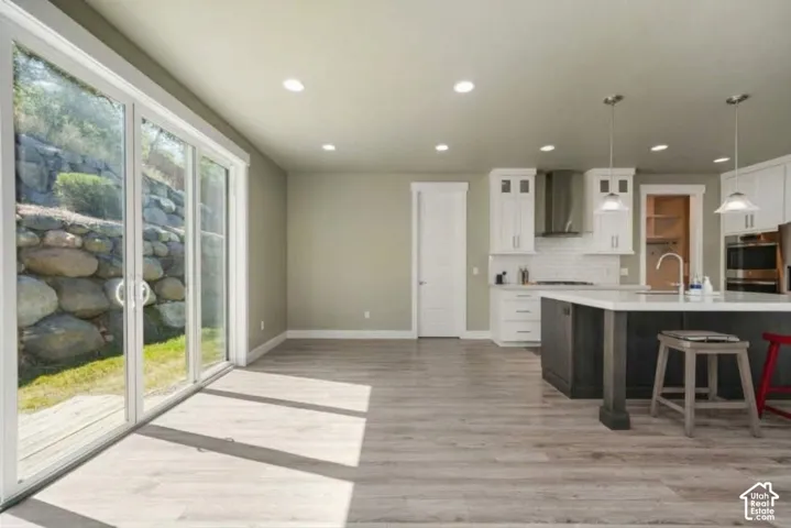 Open-concept living space with wood-finish flooring, recessed lighting, and sliding glass doors