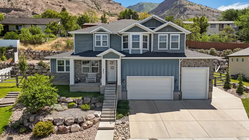 Two-story residence featuring blue siding and stone facade accents