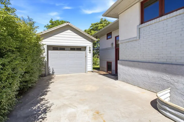 Detached garage featuring horizontal siding and a panel-style garage door with horizontal lites