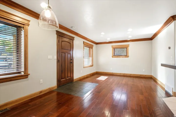 Rich wood-finish flooring complemented by substantial wood trim and crown molding