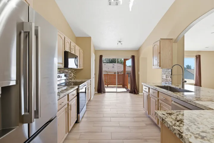 Kitchen featuring wood-finish flooring, light-toned cabinetry, and speckled countertops