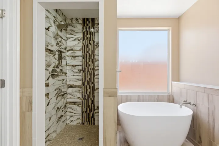 Freestanding soaking tub paired with a custom tiled shower