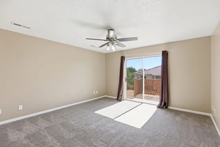 Spacious room with plush gray carpeting, neutral-toned walls, and white baseboards