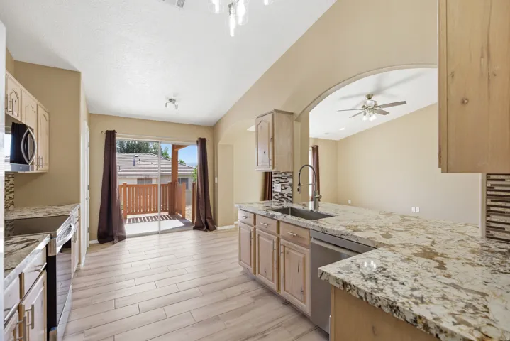 Kitchen featuring light wood-finish cabinetry, granite countertops, and stainless steel appliances
