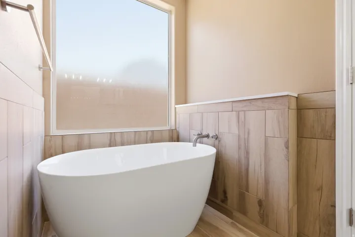 Freestanding soaking tub with wall-mounted fixtures