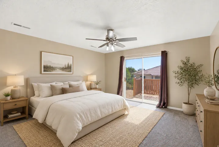 Carpeted room with a sliding glass door offering access to a private wooden deck