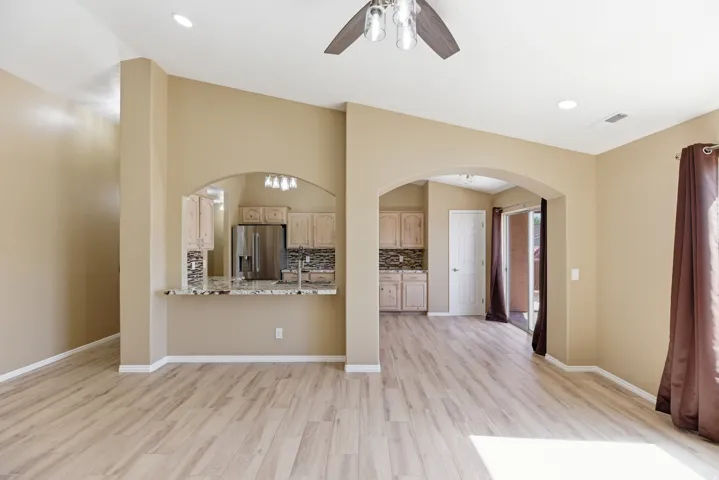 Spacious living area featuring wood-finish flooring, vaulted ceilings, and recessed lighting