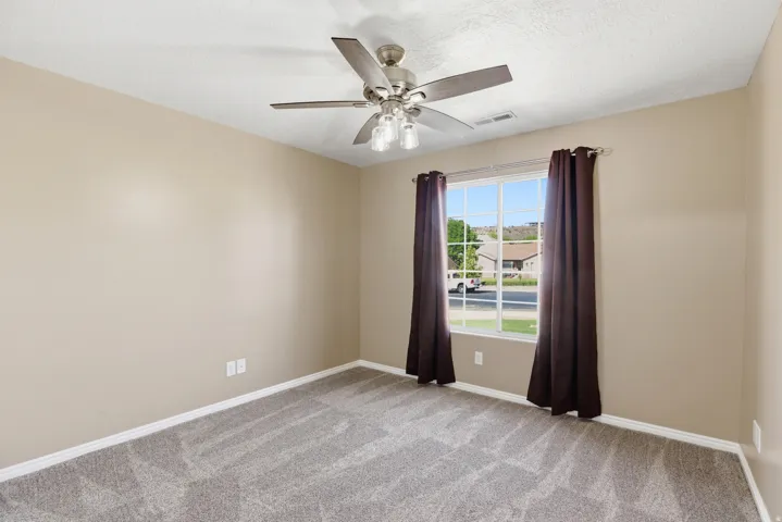 Neutral-toned walls complement plush grey carpeting