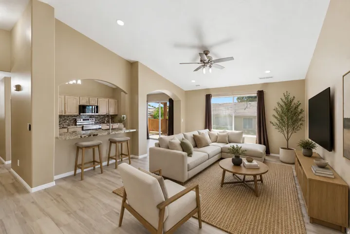 Open-concept living area featuring vaulted ceilings and wood-finish flooring