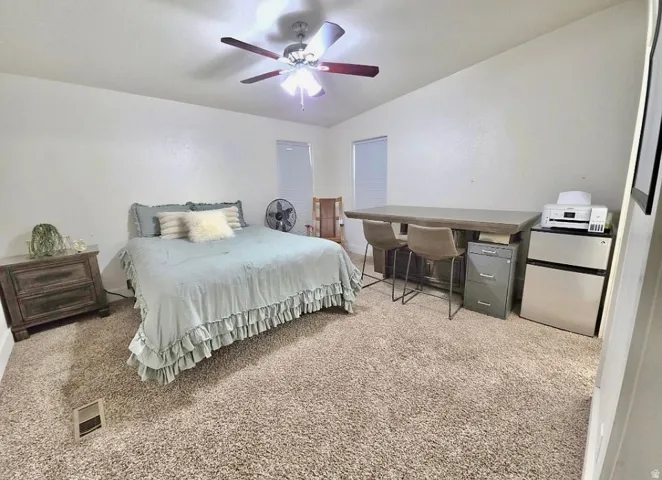 Spacious room featuring neutral carpeting and a ceiling fan