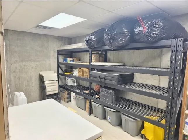 Utility room featuring concrete walls and light-toned flooring