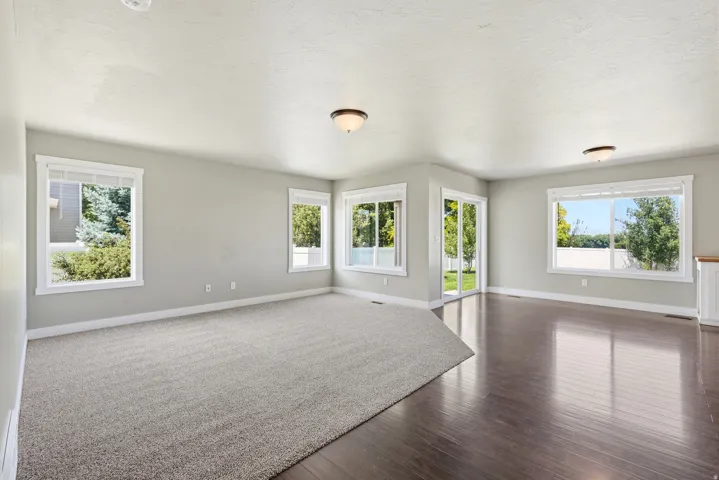 Spacious open-concept room featuring light gray walls and white trim