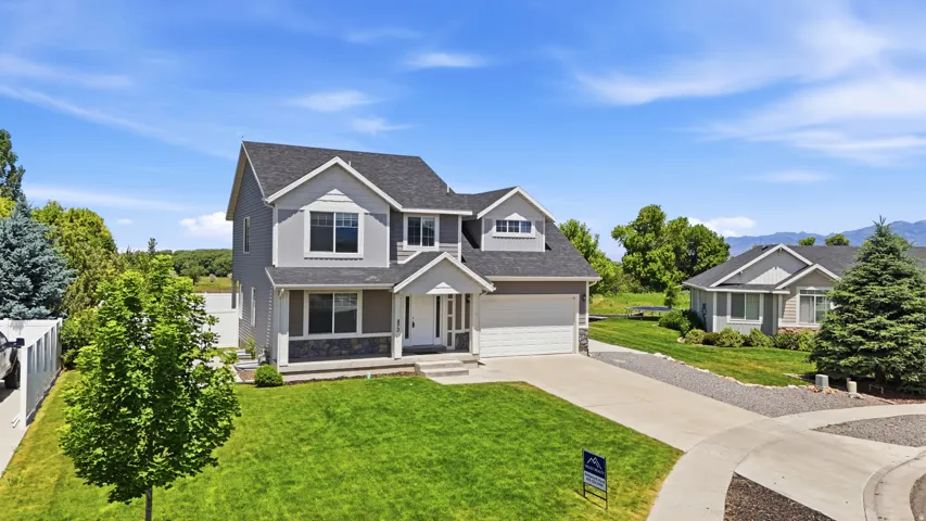 Two-story residence featuring a gray and white exterior, dark shingle roof, and an attached two-car garage