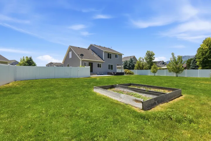 Expansive green lawn with a white vinyl fence
