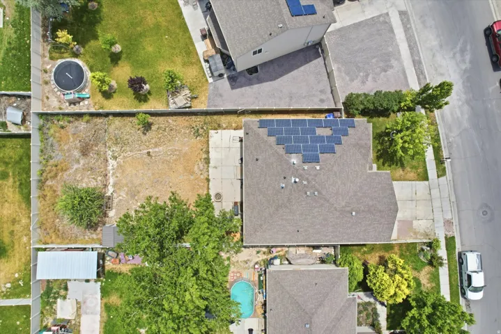 Aerial perspective showcasing a parcel with a residential structure featuring solar panel installation