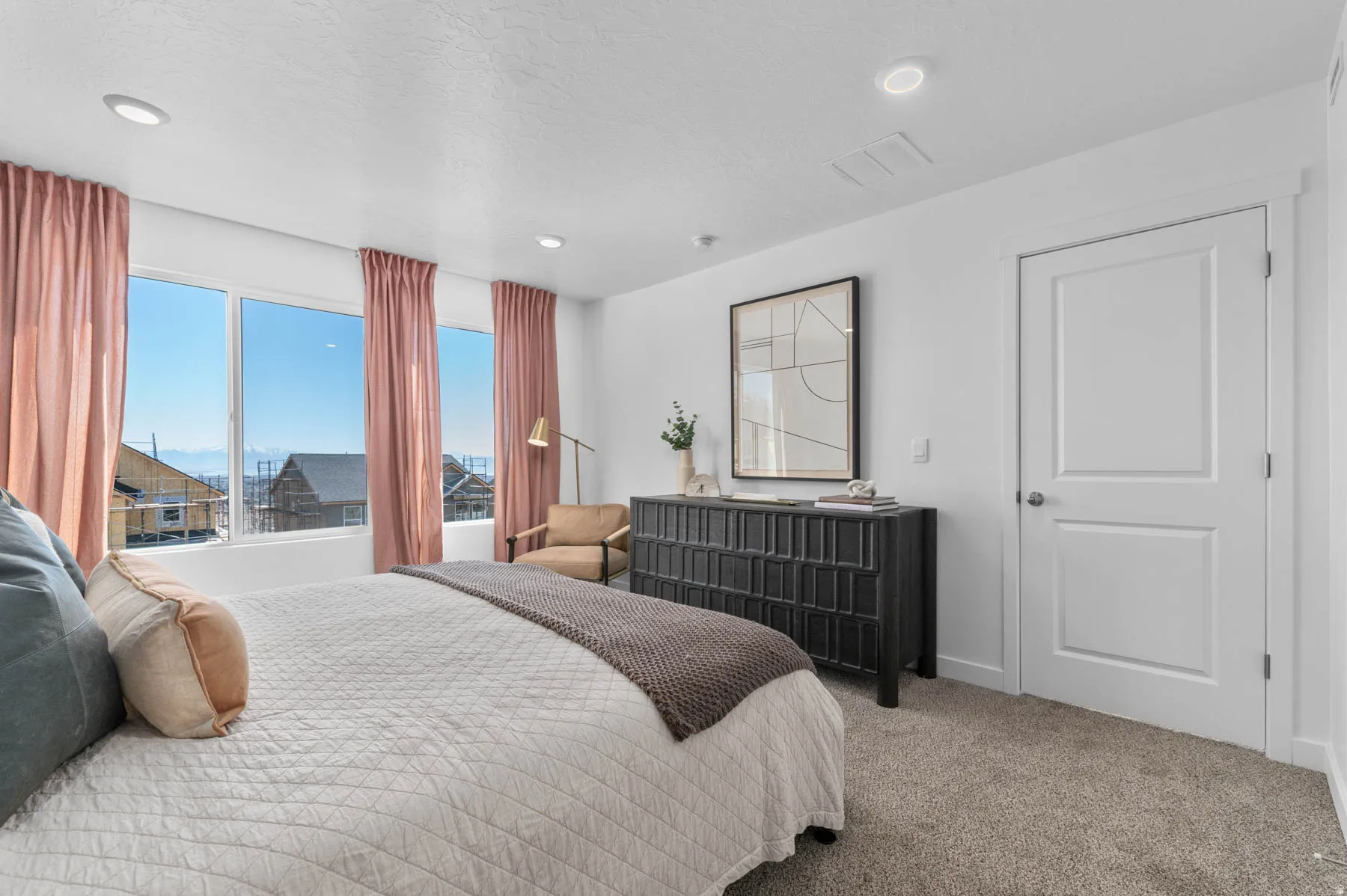 Spacious room featuring broad windows with mountain scenery, plush carpet flooring, a two-panel interior door, and recessed ceiling lighting