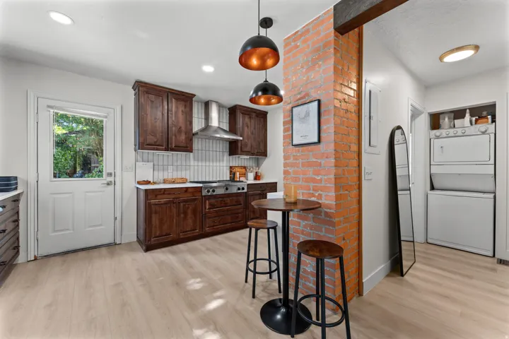 Kitchen featuring dark wood cabinetry, white countertops, and a full-height tiled backsplash