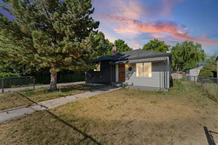 Single-story residence featuring a partial siding exterior and a large mature tree