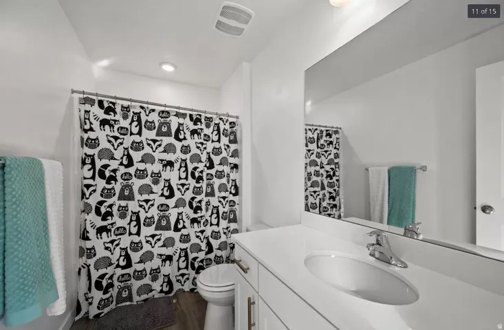 Bathroom featuring a single vanity with an integrated sink, polished chrome faucet, and white countertop