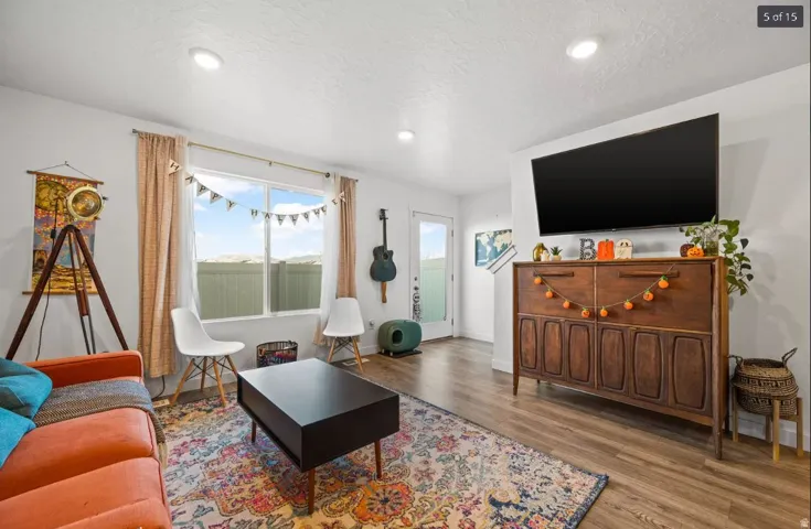 Living area featuring recessed lighting, wood-finish flooring, and a large window