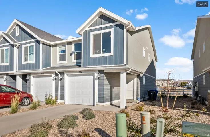 Modern townhome exterior featuring blue vertical siding and light gray horizontal siding accents