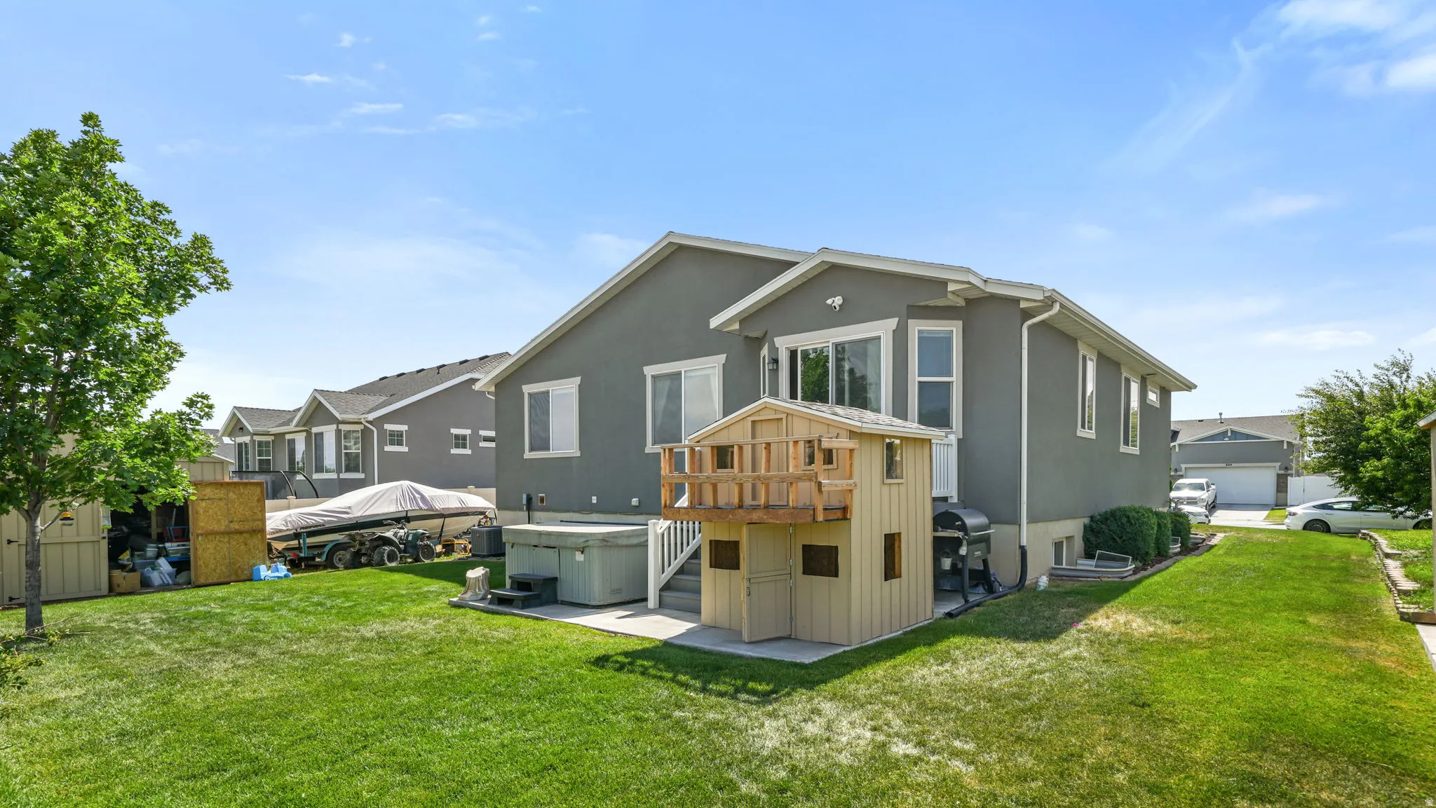 Spacious backyard featuring a manicured lawn, a concrete patio, and a built-in outdoor structure