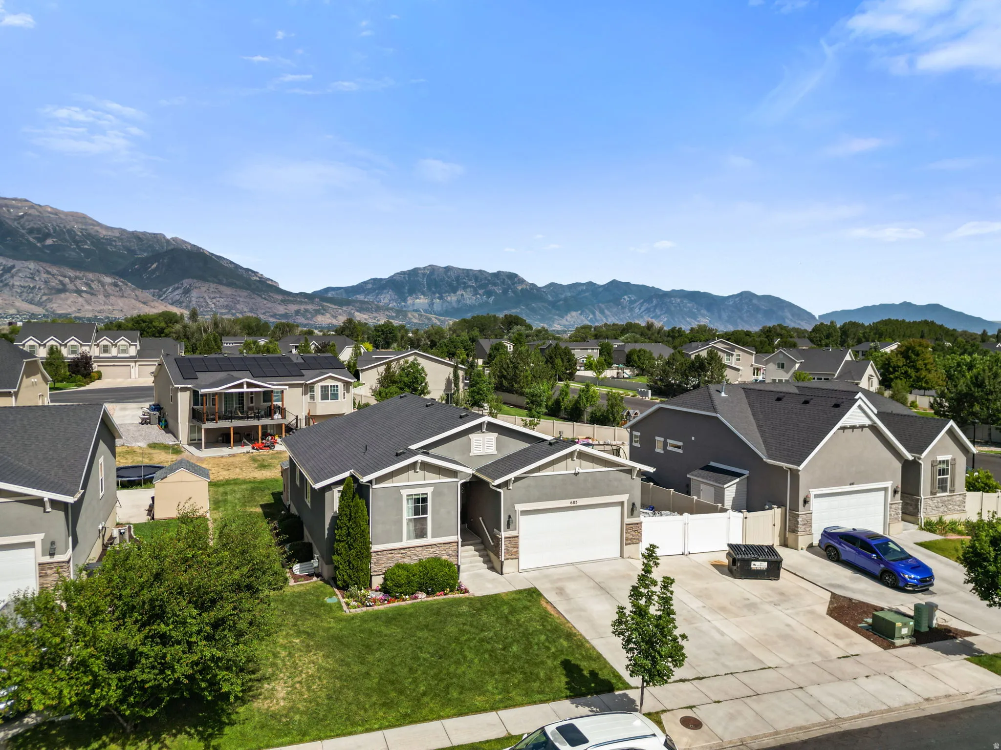 Contemporary single-story residence featuring a two-car garage, stone and siding exterior, and a manicured front lawn
