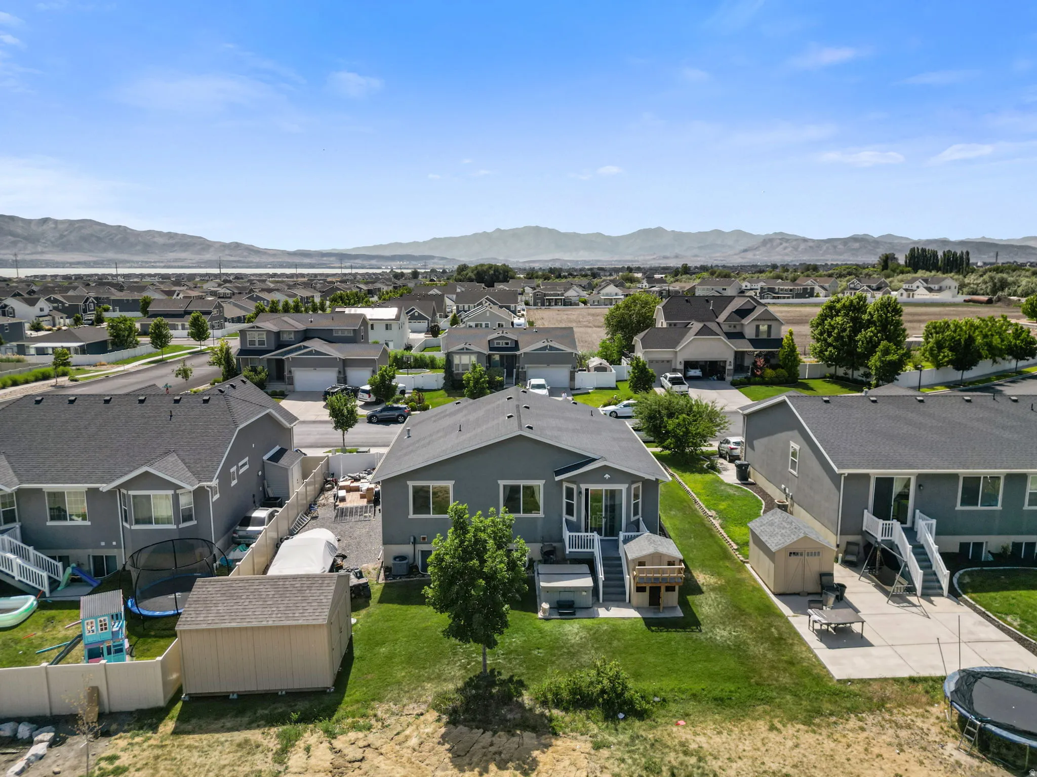 Well-maintained rear exterior featuring a deck, concrete patio, and a storage shed
