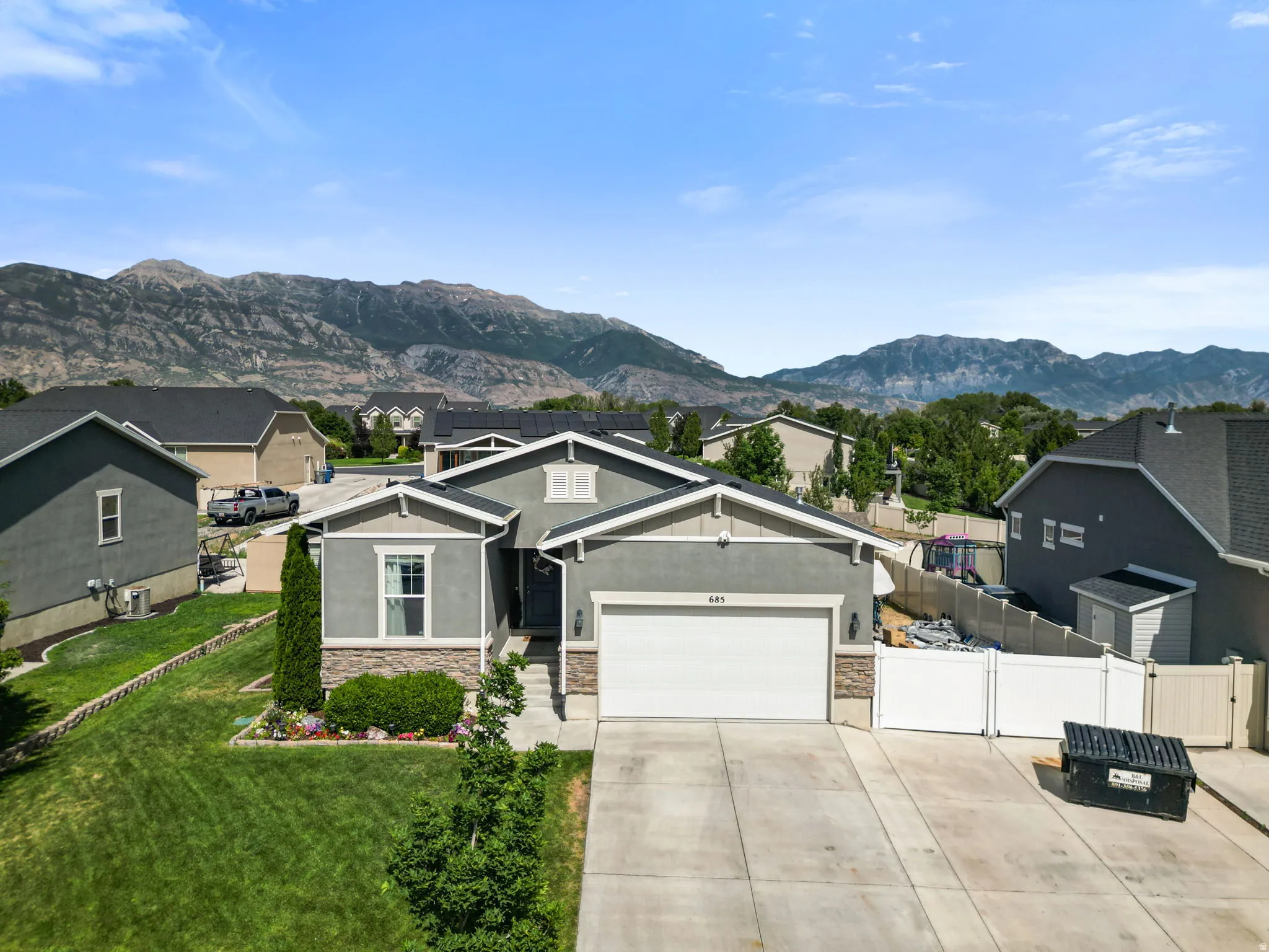 Contemporary single-story residence with a gray stucco facade and stone accents