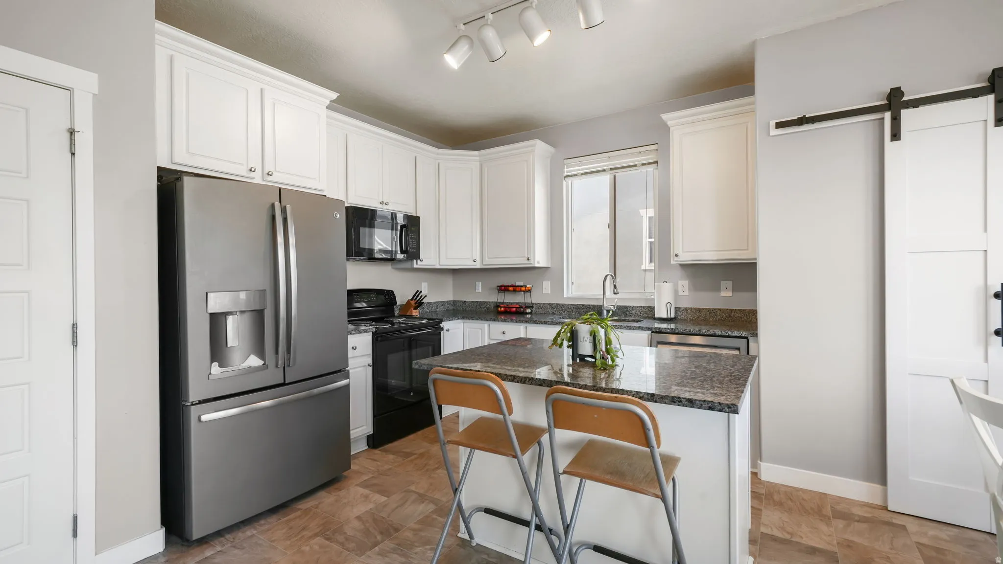 Kitchen featuring white cabinetry, granite countertops, and stainless steel appliances