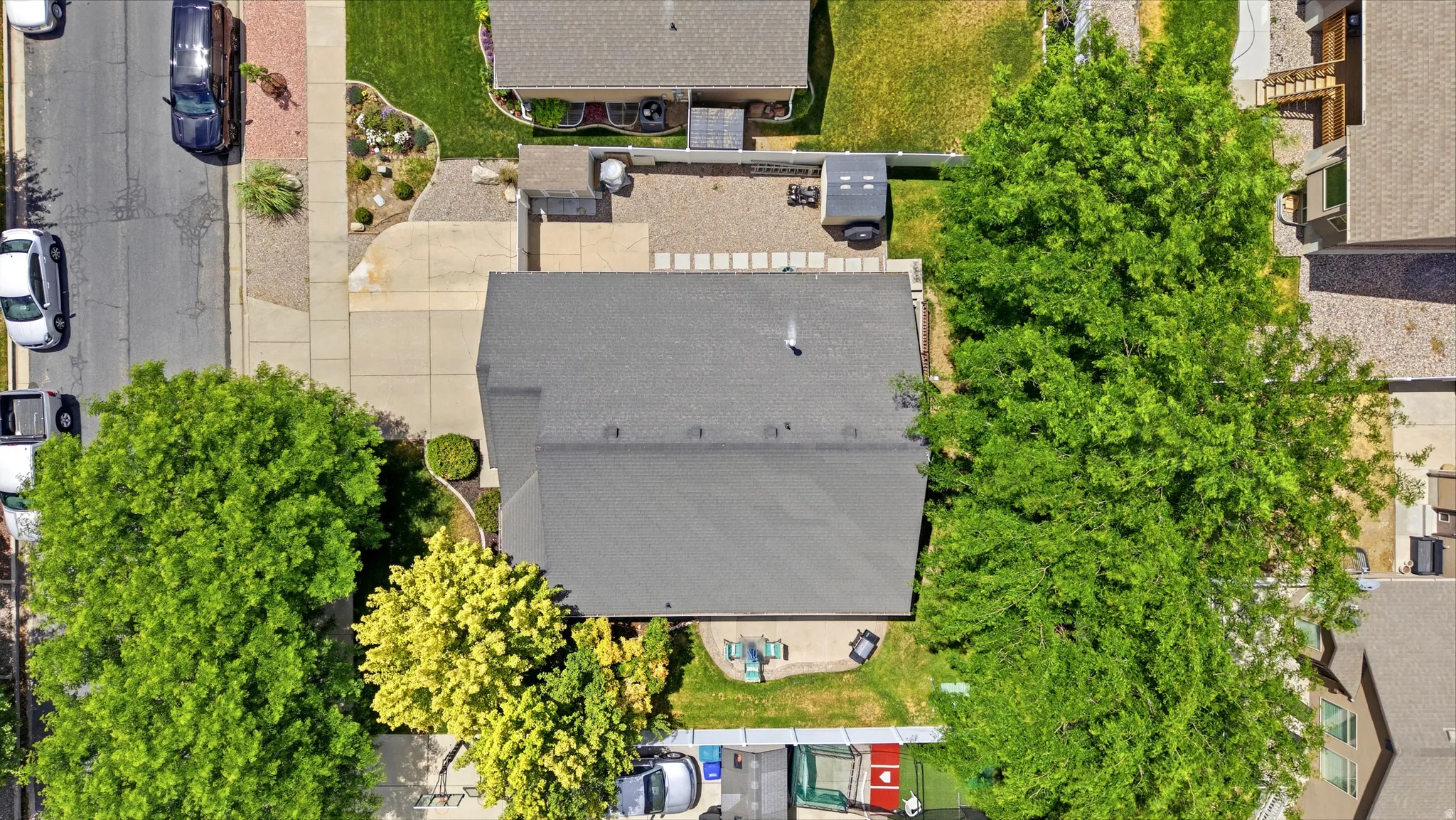 Gray shingle roof structure with a paved driveway and concrete patio