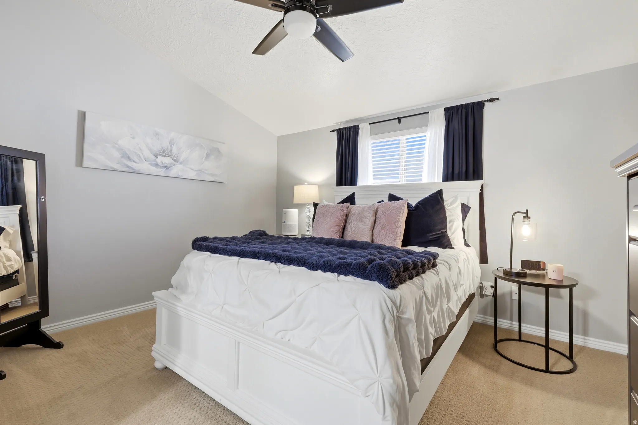 Light gray walls with vaulted ceiling and a ceiling fan